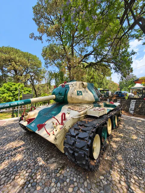 Historic tank displayed in a leafy outdoor setting