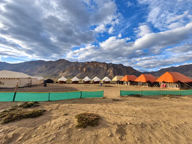 Tented camp beneath a wide mountain sky